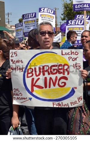 LOS ANGELES, CA   APRIL 15, 2015: A protestor holds a hand-made a sign with a Burger King logo advocating raising the minimum wage during a demonstration in Los Angeles on April 15, 2015.
