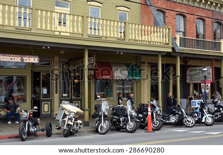 VIRGINIA CITY, NV JUNE 6, 2015: Motorcycles park along the street amid old western buildings during the seventh annual public Street Vibrations Spring Rally in Virginia City, Nevada on June 6, 2015.