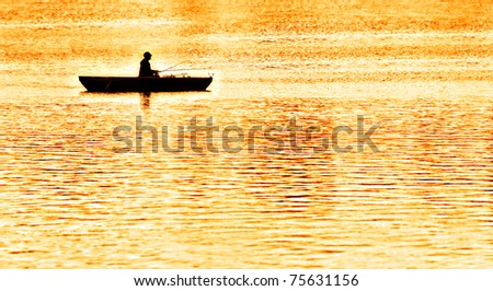 an angler fishing from a punt in the evening glow