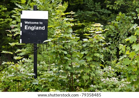 a sign welcoming visitors to england surrounded by vegetation