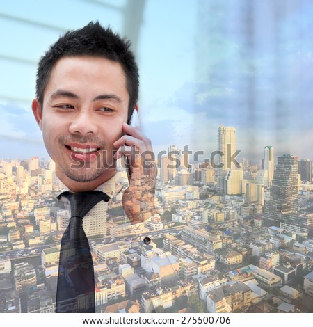 Double exposure of businessman with phone on city background.