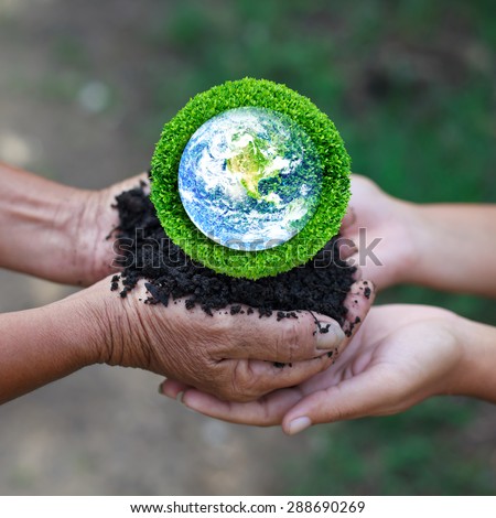 Save the earth by trees. Human hand holding global in soil with green tree for think earth concept. Elements of this image furnished by NASA.