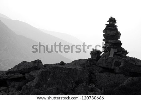 Silhouette of a stone cairn or rock pile built to serve as guidance for tourists who climb the mountains
