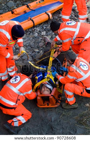 BUSSOLENO, ITALY- DECEMBER 9: Red Cross during rescue mission on December, 9, 2011 in Bussoleno, Italy. The rescue workers  move hurt person with a stretcher