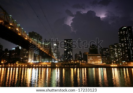 New York. Night view of the Queensborough Bridge before the storm, with lightning in the sky.