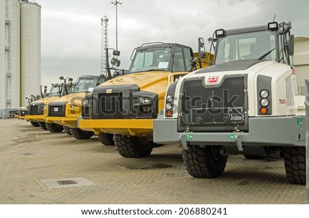 SOUTHAMPTON, UK - MAY 31, 2014: A row of new CAT articulated trucks, made by Caterpillar at the dockside in Southampton, Hampshire.  The port is an important export area for vehicles in the UK.