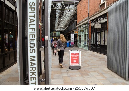 LONDON, UNITED KINGDOM - AUGUST 30, 2014:  Shoppers at the entrance to the trendy Spitalfields Market in Shoreditch, London.  The covered market is famous for fashion and is popular with hipsters.