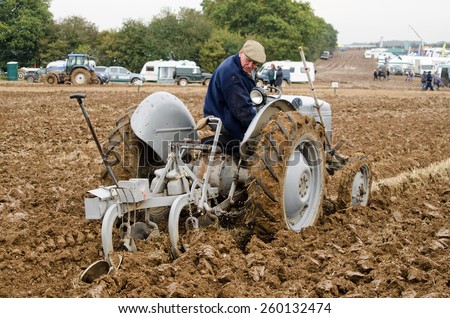 BASINGSTOKE, UK - OCTOBER 12, 2014: A competitor on a vintage tractor,  British National Ploughing Championships.  Competing in the Ferguson ploughing championship on a vintage Ferguson tractor.