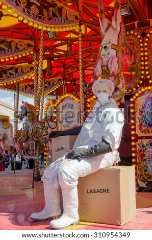 WESTON-SUPER-MARE, UK - AUGUST 26, 2015: A parody of a horse carousel with an abattoir worker preparing horsemeat lasagne at Dismaland, the ironic theme park by Banksy at Weston-Super-Mare, Somerset.