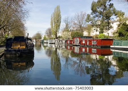 Rows of houseboats and narrow boats on the canal banks at Little Venice, Paddington, West London.  The Grand Union Canal meets the Regent\'s Canal here.