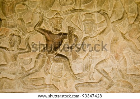 Ancient Khmer bas relief carving of gods fighting demons, devas versus asuras.  Inner wall of the temple of Angkor Wat, Siem Reap, Cambodia.