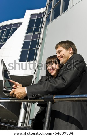 Business couple with Laptop outside a modern office