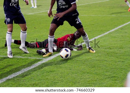 BANGKOK THAILAND - APRIL 2 :K.Christian (red) hurt in action at Thai Premier League (TPL) between Muang Thong utd (Red) vs Buriram Fc (Blue) on April 2, 2011 at Yamaha Stadium Bangkok, Thailand