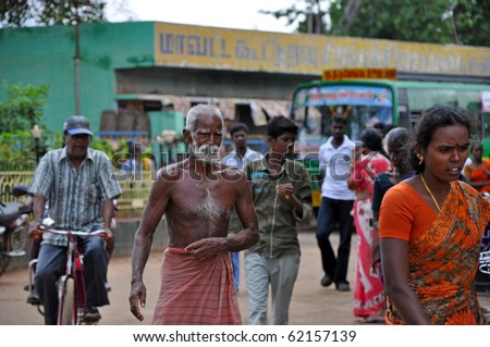 MADURAI, INDIA - NOV 7: Poor indian man nearly without dress walks on the street in Madurai on November 7, 2009. Poverty is the serious problem in the whole India.