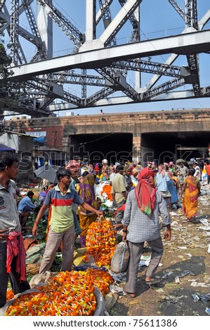 KOLKATA, INDIA - 27 OCTOBER: Indian people buy and sell flowers on flower market under the Howrah Bridge in Kolkata on October 27, 2009.  The  market is the largest one in eastern India.