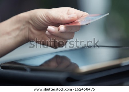 Human hand with digital tablet and credit card