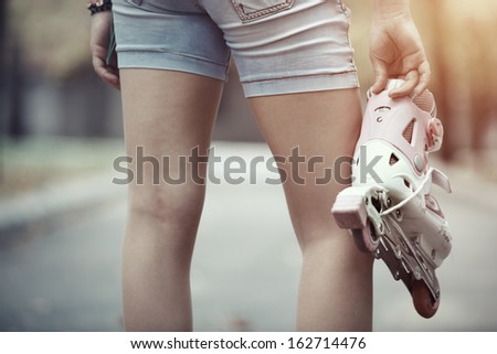 Close-up view on teenager holding roller skate