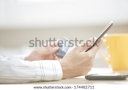 Human hand with tablet PC and credit card during lunch