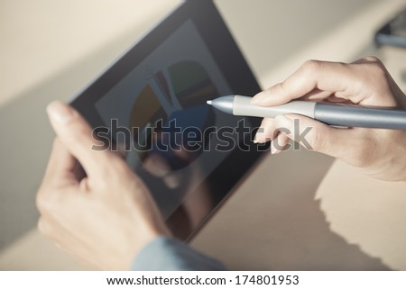 Human hands using tablet PC and sylus for diagram working. Diagram was created by me