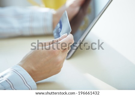 Hands of woman using digital tablet and credit card