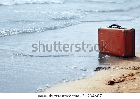 Lost orange handbag on the beach