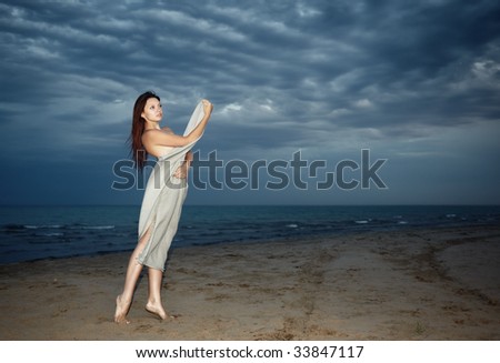 Sexy lady at the beach during the bad weather