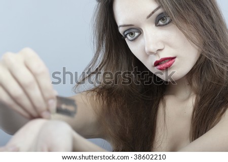 Close-up portrait of the sad lady cutting veins by razor