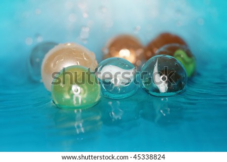 Extremely close-up macro photo of the glassy balls in the water. Shallow depth of field for natural view