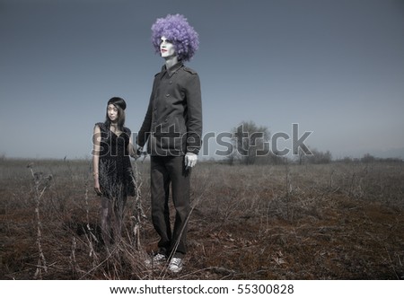 Bizarre couple outdoors. Little girl together with tall funnyman. Artistic colors added