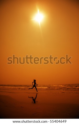 Woman running at the hot beach in the dark night. Artistic red and yellow color toning added