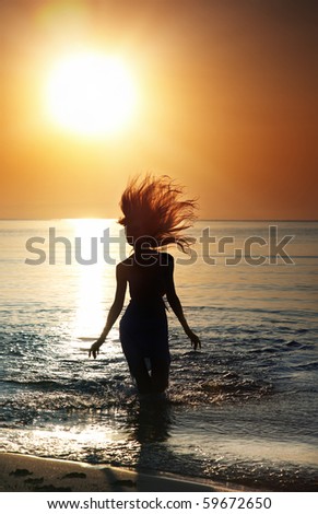 Silhouette Of The Woman With Long Hairs Running In The Sea During ...