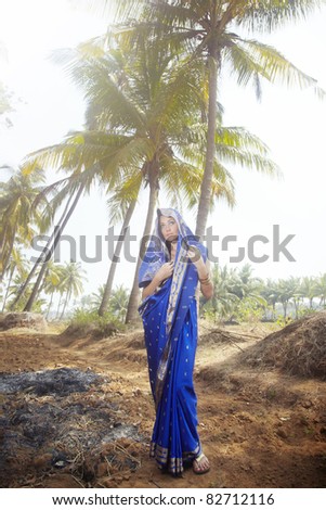Rural woman in blue sari standing in jungle