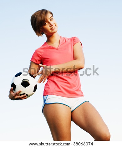 Young woman playing soccer in a field, from a complete series of photos.