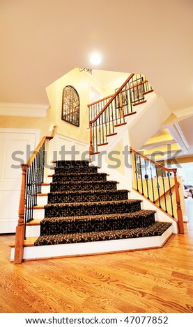 Low angle view of staircase and entryway in an upscale home. Vertical format.