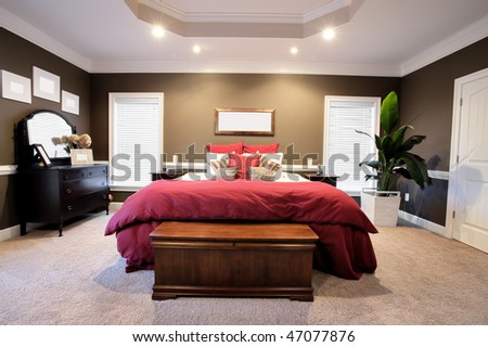 Interior of a large modern bedroom with a fireplace and ceiling fan. Horizontal format.