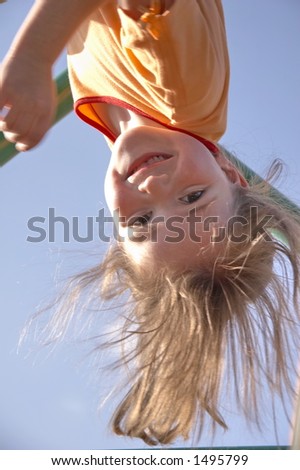 child on climbing pole - head first and laughing