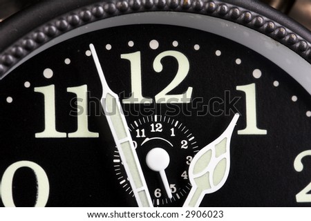 Old alarm clock on black background with black clock face