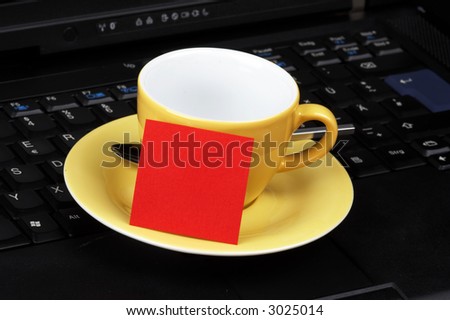 yellow cup with red post-it on black laptop