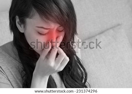 sick woman suffers from flu, cold, running nose, asian caucasian indoor scene