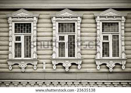Three windows with carved wooden cases. Traditional for Russian country architecture. Monochrome