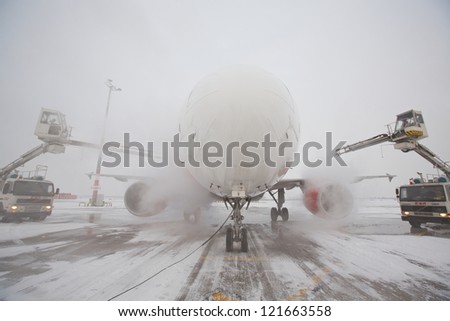 PRAGUE - DECEMBER 11: Ground crew of Czech Airlines Handling provides de-icing. They are spraying the aircraft, which prevents the occurrence of frost on December 11, 2012 in Prague, Czech Republic.