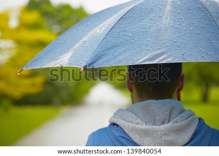 Rainy day - young man with umbrella