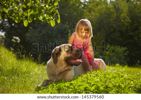 Little girl with large dog in the garden