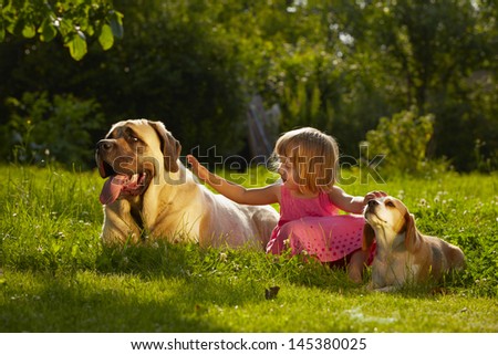 Girl with little and large dogs in the garden
