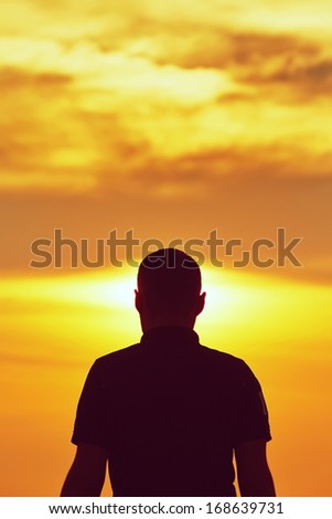 Silhouette of young man at sunset - copy space