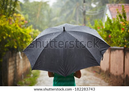 Woman with black umbrella in heavy rain