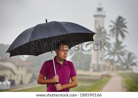 Man with black umbrella in heavy rain