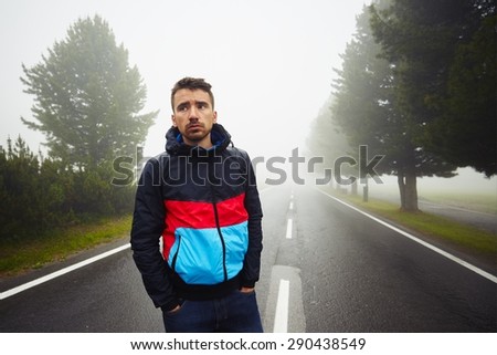 Sad man in fog on the road