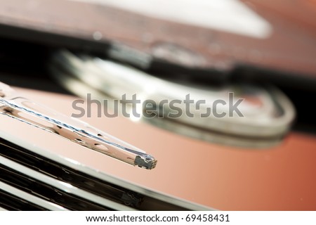 Hard drive disk. Focused on magnetic read write head. Color manipulated by reflection.