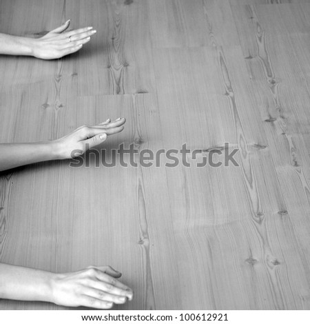 Yoga training, three hands on the wooden floor